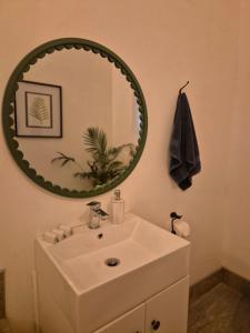 a bathroom with a white sink and a mirror at Under the Maple in Rawsonville +16 photos