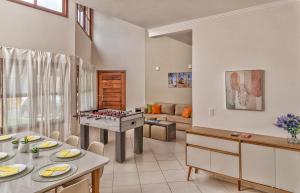 a living room with a table with a game at 400 m te Separam das Areias da Praia de Boraceia, casa com piscina aquecida para ate 12 pessoas in São Sebastião