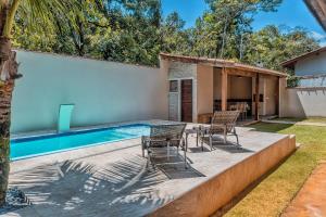 a backyard with a swimming pool and two chairs at 400 m te Separam das Areias da Praia de Boraceia, casa com piscina aquecida para ate 12 pessoas in São Sebastião