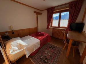 a small bedroom with a bed and a television at Alla Frasca Verde in Lauco