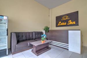 a living room with a couch and a table at Hotel O Pekanbaru near Mall Ciputra Seraya formerly Lotus Inn in Pekanbaru