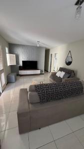 Piranhas casa de temporada في ببرانا: غرفة معيشة كبيرة مع أريكة وتلفزيون