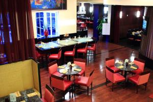 圣彼得堡圣彼得堡克利尔沃特万豪酒店的有桌子和红色椅子的餐厅