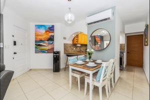 a dining room with a table and chairs and a mirror at El Neptuno Residencial, Sosua in Sosúa