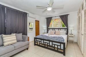 a bedroom with a bed and a couch and a ceiling fan at El Neptuno Residencial, Sosua in Sosúa +20 photos