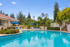 a swimming pool at a resort with chairs and umbrellas at El Neptuno Residencial, Sosua in Sosúa