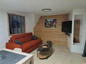 a living room with a couch and a tv at le Cocon in Montgardin
