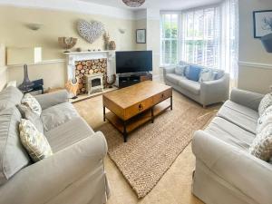 a living room with two couches and a fireplace at Bora House in Newquay