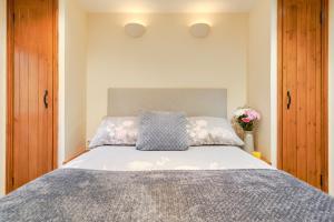 een slaapkamer met een bed met twee kussens erop bij Finest Retreats - The Barn at St Just in St Just