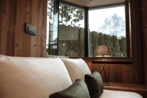 - un salon avec un canapé, une lampe et une fenêtre dans l'établissement Appartamenti Olympic, à Santa Cristina Valgardena