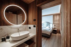 une salle de bains avec un lavabo et un miroir dans l'établissement Appartamenti Olympic, à Santa Cristina Valgardena 31 autres photos