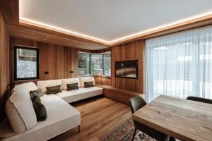 un salon avec un canapé et une table dans l'établissement Appartamenti Olympic, à Santa Cristina Valgardena