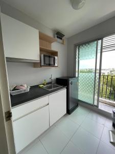 een keuken met een spoelbak en een magnetron bij studio123 at Changwattana in Ban Bang Phang