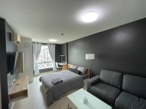 een slaapkamer met een bed en een bank bij studio123 at Changwattana in Ban Bang Phang