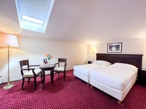 a bedroom with two beds and a table and chairs at Amadria Park Hotel Agava in Opatija