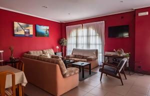 sala de estar con paredes rojas, sofá y mesa en Hotel Rural en Escalante Las Solanas, en Escalante