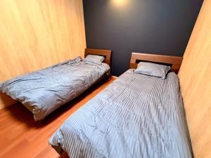 Dos camas una al lado de la otra en una habitación. en A Lucky Hostel, en Hakuba