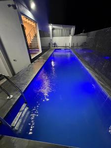 Una gran piscina con agua azul por la noche. en Yelagiris Honey Stay, en Yelagiri