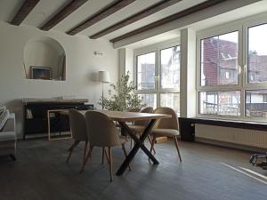 ein Esszimmer mit Tisch und Stühlen und Fenstern in der Unterkunft Ferienwohnung Hänsel und Gretel in Sasbachwalden