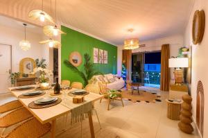 a living room with a table and a green wall at Lamarel Beach House 2 in Flic-en-Flac