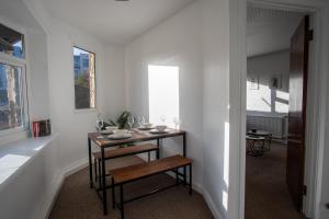 a white room with a small table and chairs in it at Spacious Canalside Cottage - Games Room - Dog Walks in Loughborough