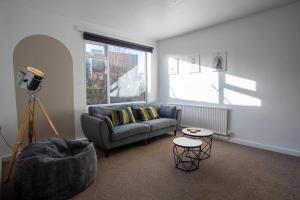 a living room with a couch and a table at Spacious Canalside Cottage - Games Room - Dog Walks in Loughborough +14 photos