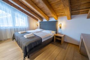 a bedroom with a large bed and a wooden ceiling at Matthiol Appartements in Zermatt +51 photos