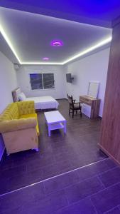 uma sala de estar com um sofá amarelo e uma mesa em Suits Mirasol em Tânger