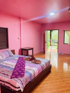 a pink bedroom with a bed and a wooden floor at Pizza classic resort kohjum in Ban Ko Phrao +23 photos