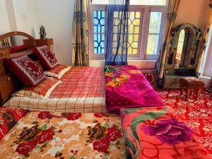 a bedroom with two beds with colorful pillows at Habib Guest House GULMARG 11 in Tangmarg