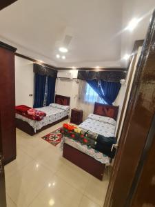 een kamer met 2 bedden en een bank bij بحر مباشر 2 in Alexandrië +5 foto's