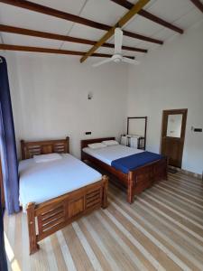 Aruna homestay في بولوناروا: غرفة نوم بسريرين وسقف