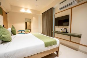 Sasya Elegance - A Boutique Hotel في Lingampalli: غرفة فندق بها سرير وتلفزيون