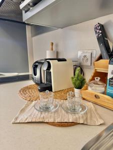 a kitchen counter with a toaster and glasses on a table at Lac & Love - Alpine Escape in Crans-Montana
