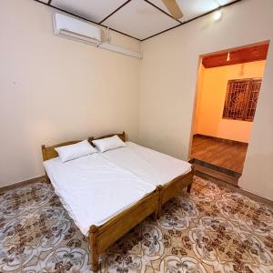 een slaapkamer met een bed in een kamer bij Jaffna Stay Guest House in Jaffna
