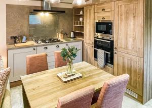 una cocina con una mesa de madera con un jarrón. en Holderness Country Park, en Tunstall 19 fotos más