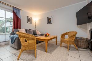 a living room with a couch and a table and chairs at Reihenendhaus Celebes in Dierhagen