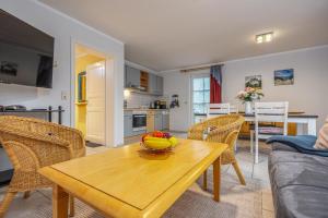 a living room with a table with a bowl of fruit on it at Reihenendhaus Celebes in Dierhagen