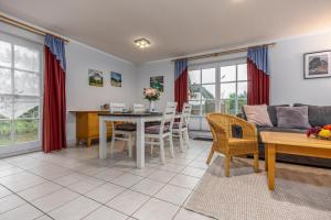 a living room with a table and a couch at Reihenendhaus Celebes in Dierhagen +10 photos