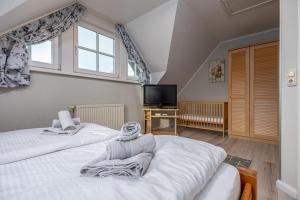 two beds in a room with a window and a tv at Reihenendhaus Celebes in Dierhagen
