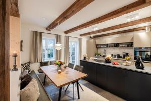 een keuken en een woonkamer met een houten tafel bij Sylter Strandholz in Westerland
