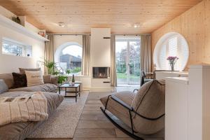 een woonkamer met een bank en een open haard bij Sylter Strandholz in Westerland