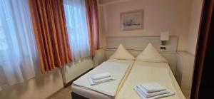 een slaapkamer met een bed met twee handdoeken erop bij Pension M in Neurenberg