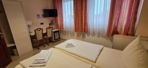 een hotelkamer met een bed, een tafel en stoelen bij Pension M in Neurenberg