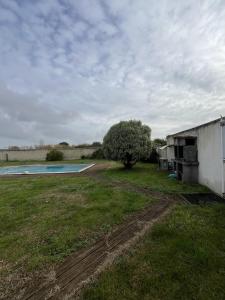 une cour vide avec une piscine et un arbre dans l'établissement Villa Oyala avec piscine, spacieuse et de qualite, à Saint-Pierre-dʼOléron 30 autres photos