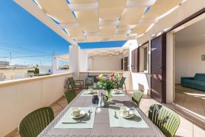 een eetkamer met een tafel en stoelen op een balkon bij Casa Agnese by BarbarHouse in Leuca