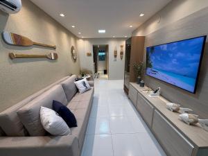 ein Wohnzimmer mit einem großen TV an der Wand in der Unterkunft Maria Farinha Residence / Prince - LocarHouse in Maria Farinha