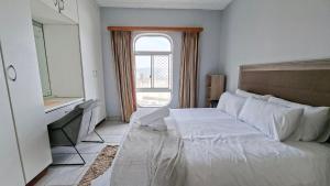 a bedroom with a large white bed with a window at Seagull 505 in Margate