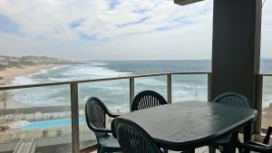 a table with chairs and a view of the ocean at Seagull 505 in Margate