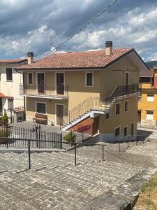a yellow house with a fence in front of it at B & B IL TRATTURO in San Pietro Avellana